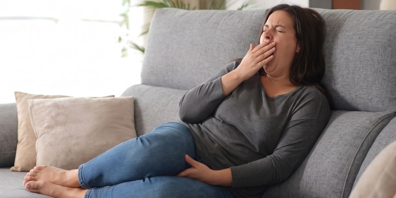 Woman yawning on a sofa