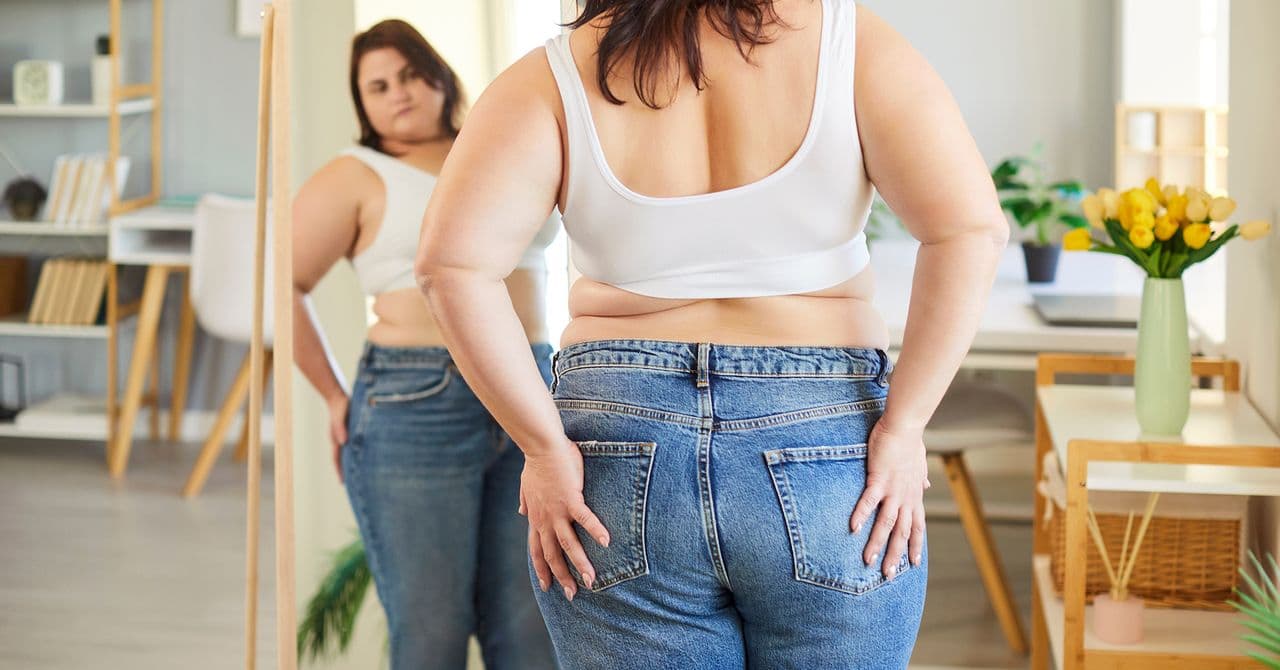An image of a woman noticing how much weight she'd lost on treatment.