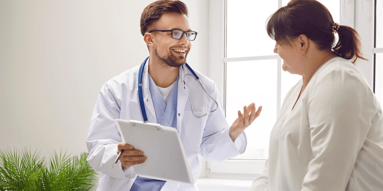 A young male doctor speaking to a female patient, offering her support and medical advice for her weight regain after stopping her weight loss treatment.